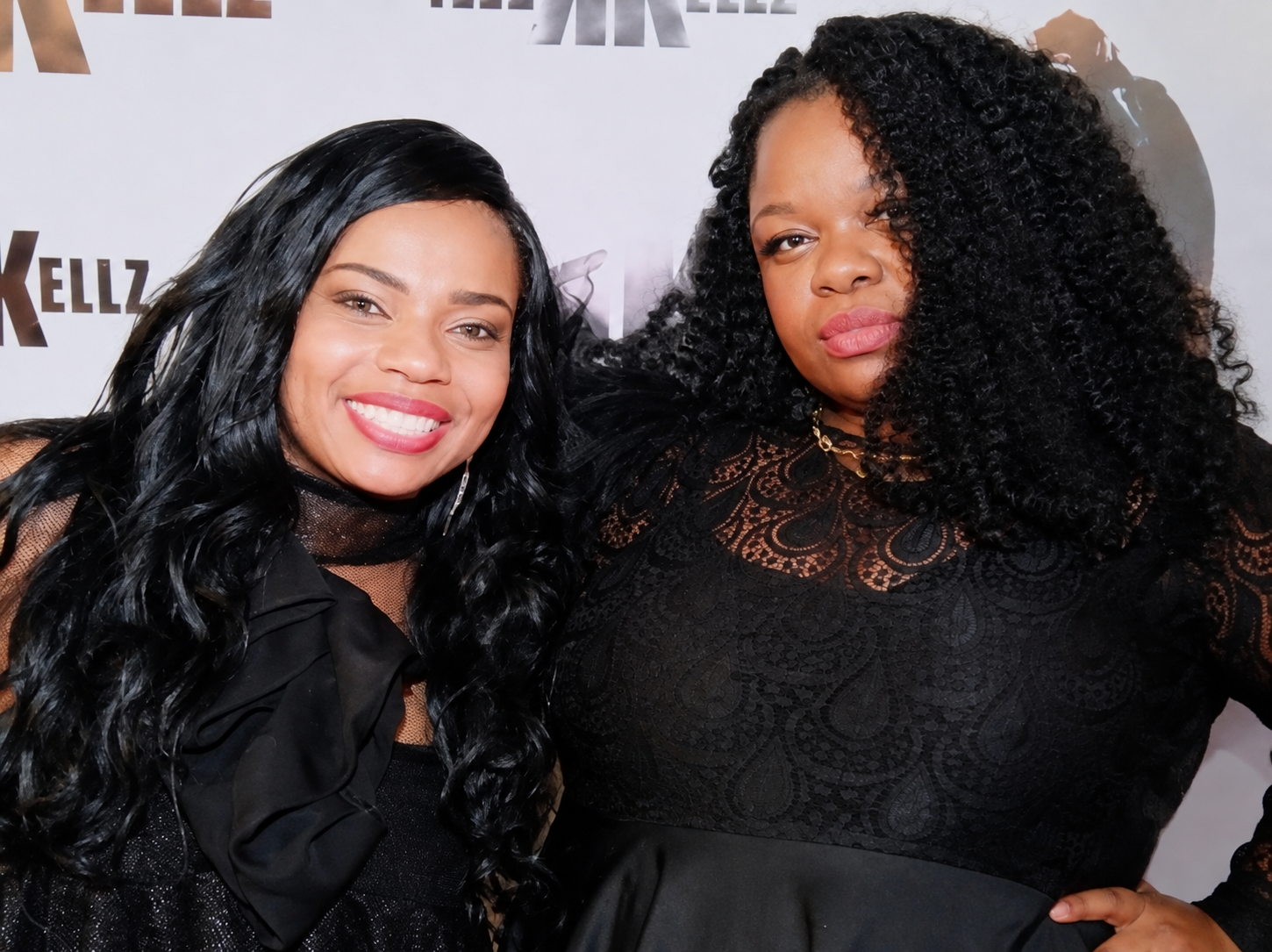 Therese Marie in a black lace top with ruffled shoulder, smiling with comedy legend Kelly Kellz on the BET Def Comedy Jam red carpet
