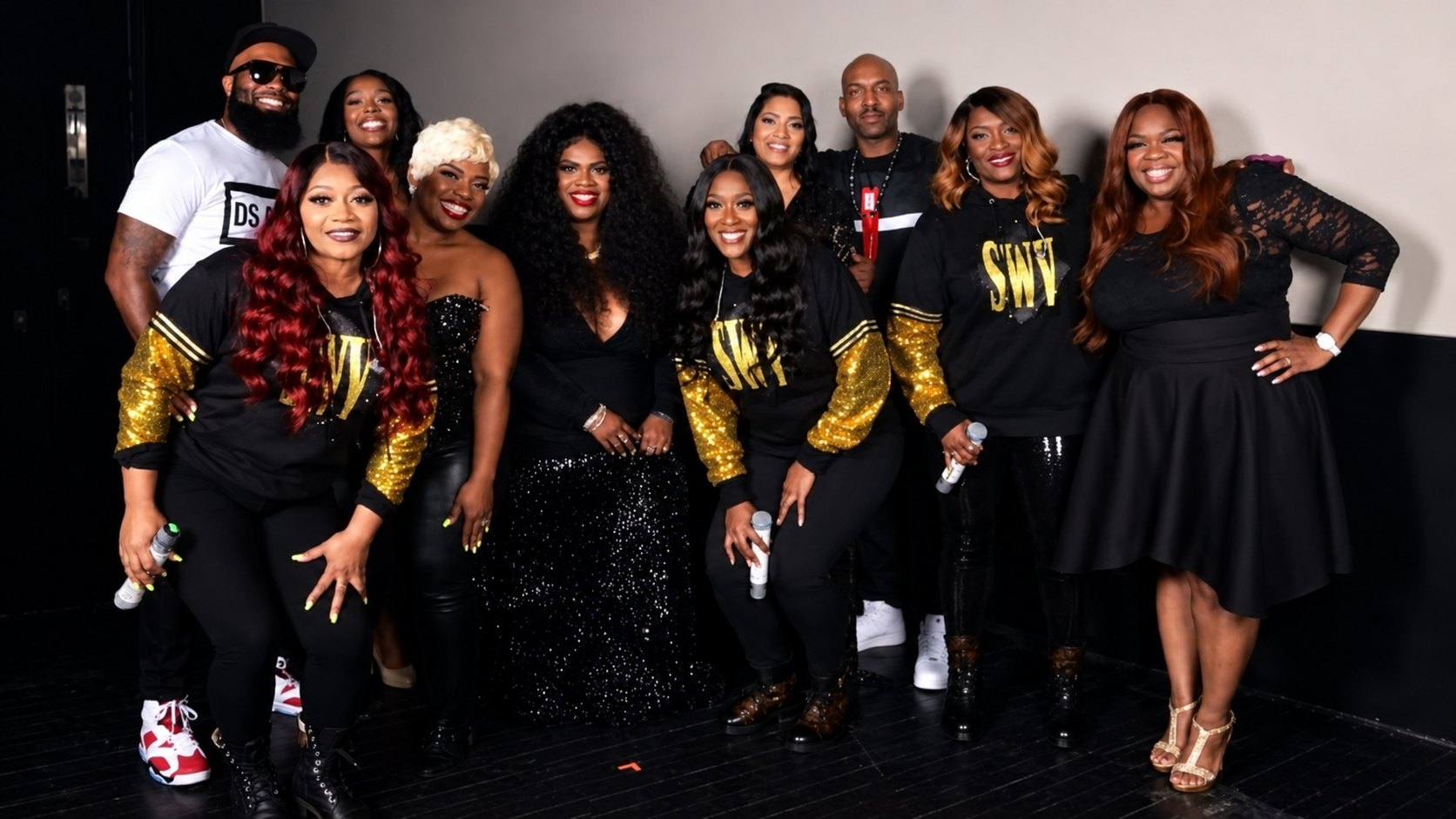 Therese Marie in a black lace dress posing backstage with the R&B group SWV and guests